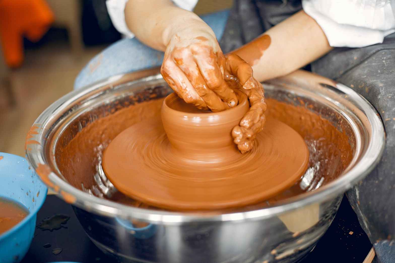ceramist molding earthenware on wheel
