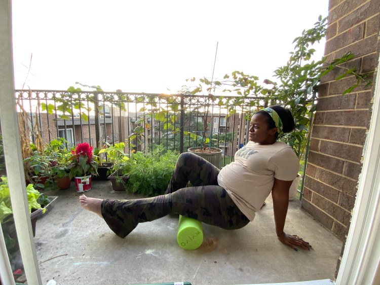 Michelle using a green foam roller on the hamstring