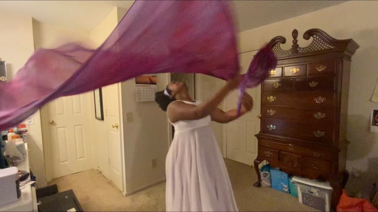 Michelle worshiping with purple flags