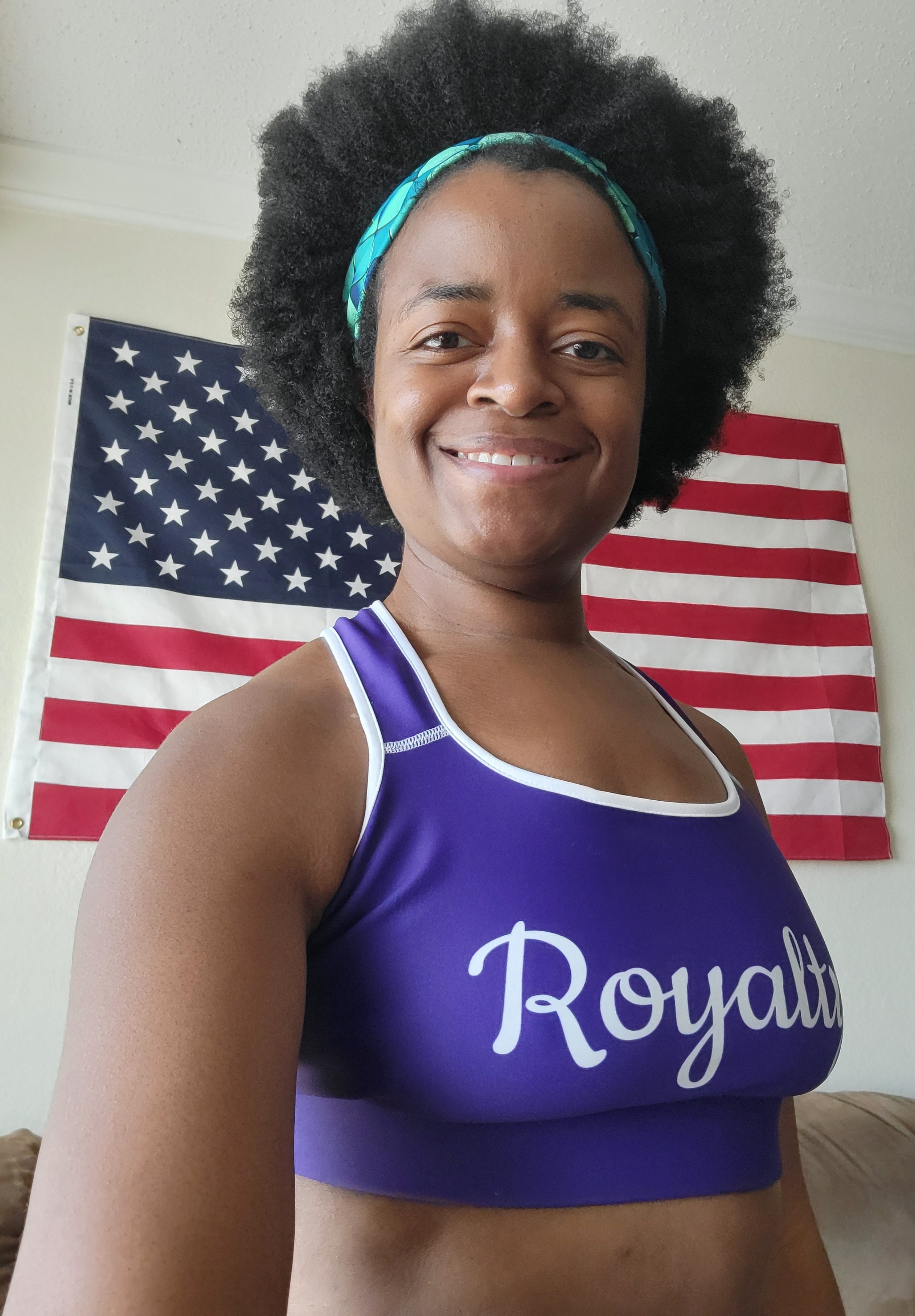 MichelleBarnes wearing Royalty Sports Bra & Green Gems Headband in front of American Flag