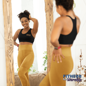 Woman wearing Jesus Set Me Free sports bra and looking at herself in the mirror