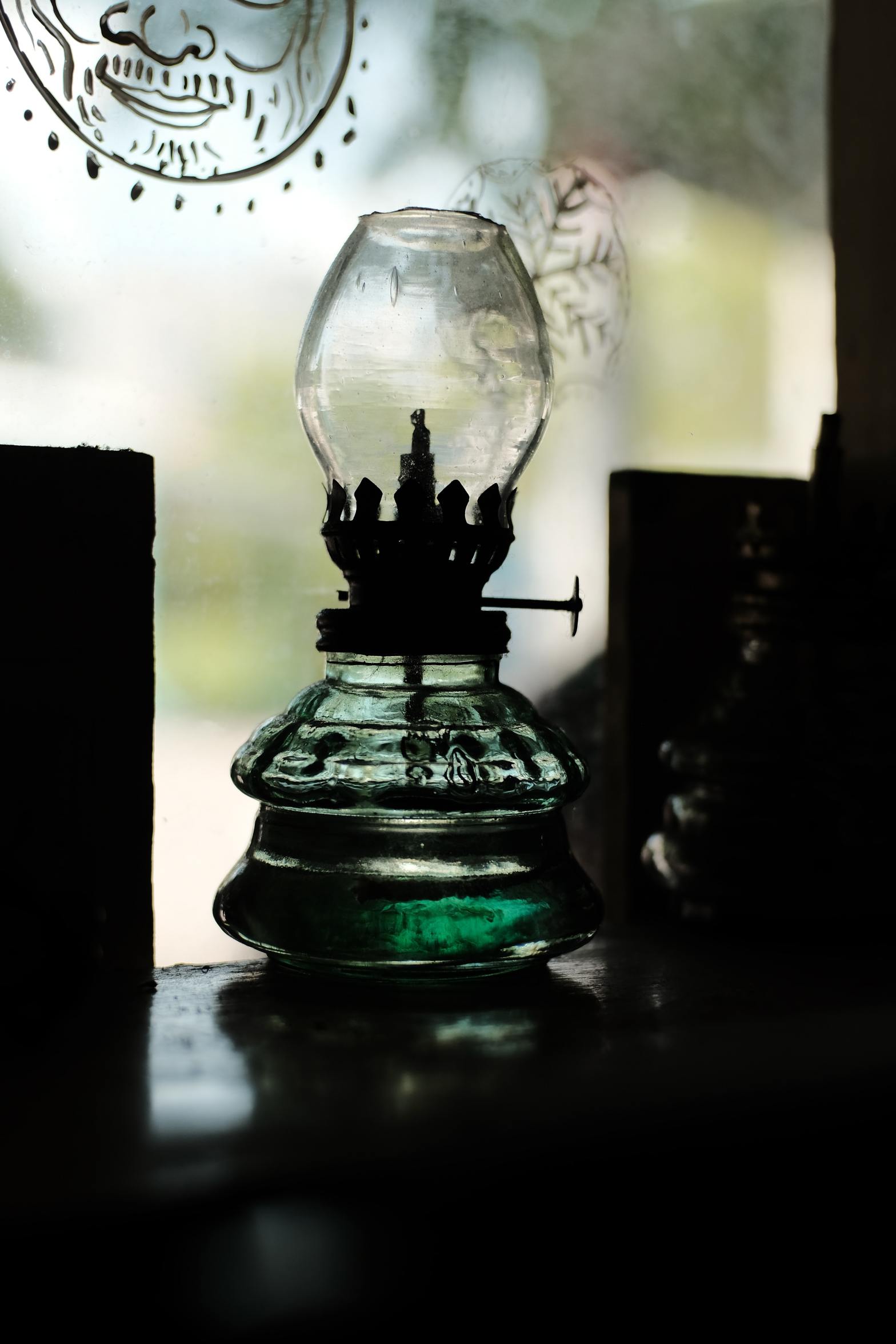 Empty oil lamp sitting in a window